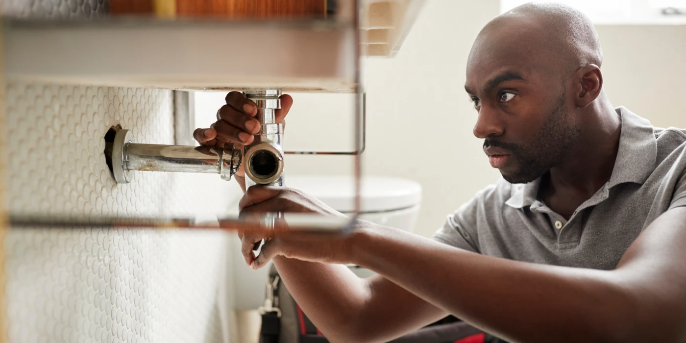 a male plumber fixing a pipe connection from Plumbing Lake Travis in Austin, TX Plumber near me a male plumber fixing a pipe connection from Plumbing Lake Travis in Austin, TX Plumber near me