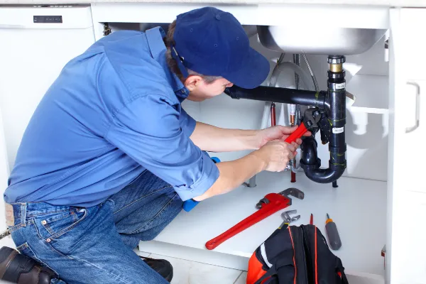 a male plumber fixing a toilet from Plumbing Lake Travis in Austin, TX Plumber near me a male plumber fixing a toilet from Plumbing Lake Travis in Austin, TX Plumber near me